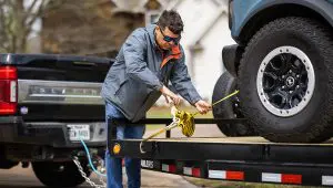 Man strapping Ford Bronco to 5