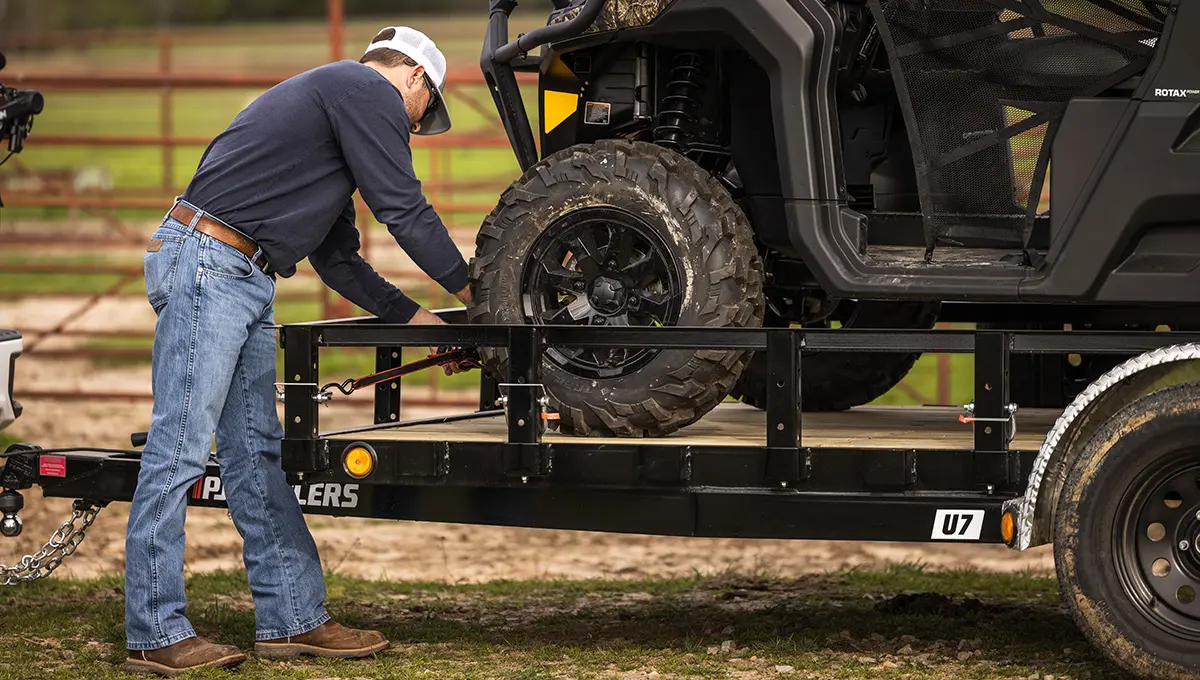 Worker strapping an ATV to the 77