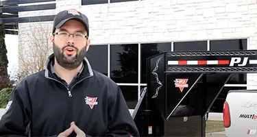 pj trailer employee standing in front of a trailer hooked to a truck