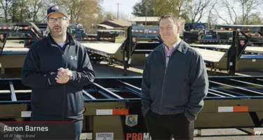 aaron Barner and another pj employee standing in front of trailers speaking