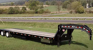 trailer parked in the grass next to the road