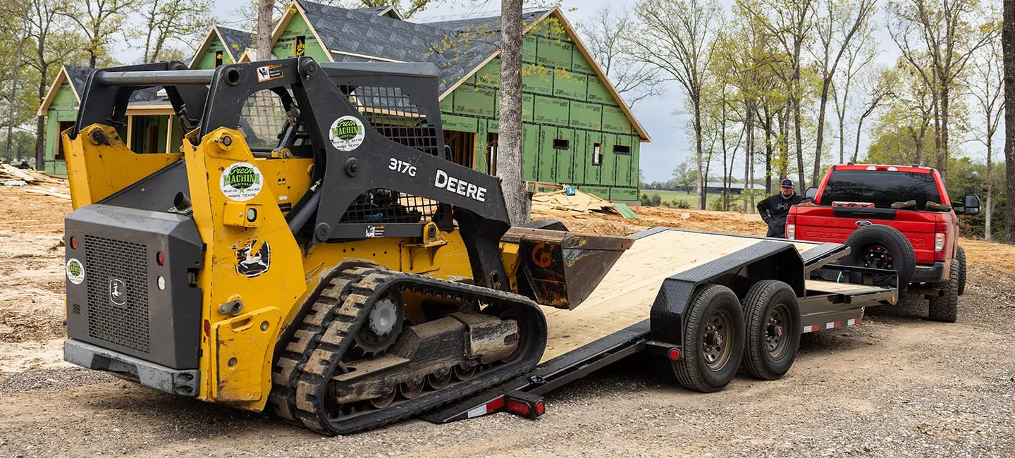 unloading a bulldozer off of a tilt trailer