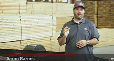 aaron barnes standing in front of wood pallets and trailer