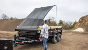 Worker raising the swing arm tarp on the Voyager Dump Trailer (DV)