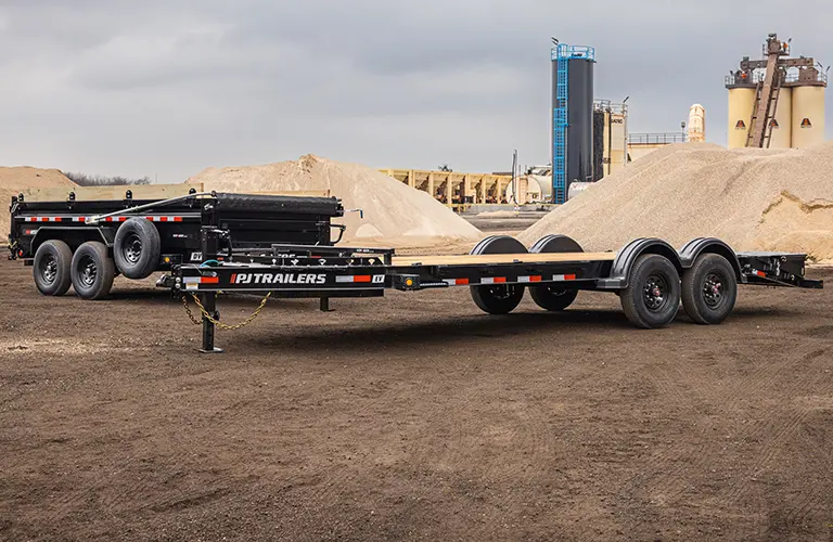 The Voyager Seamless I-Beam Equipment Trailer (EV) and Voyager Dump Trailer (DV) sitting together inside an aggregate material site