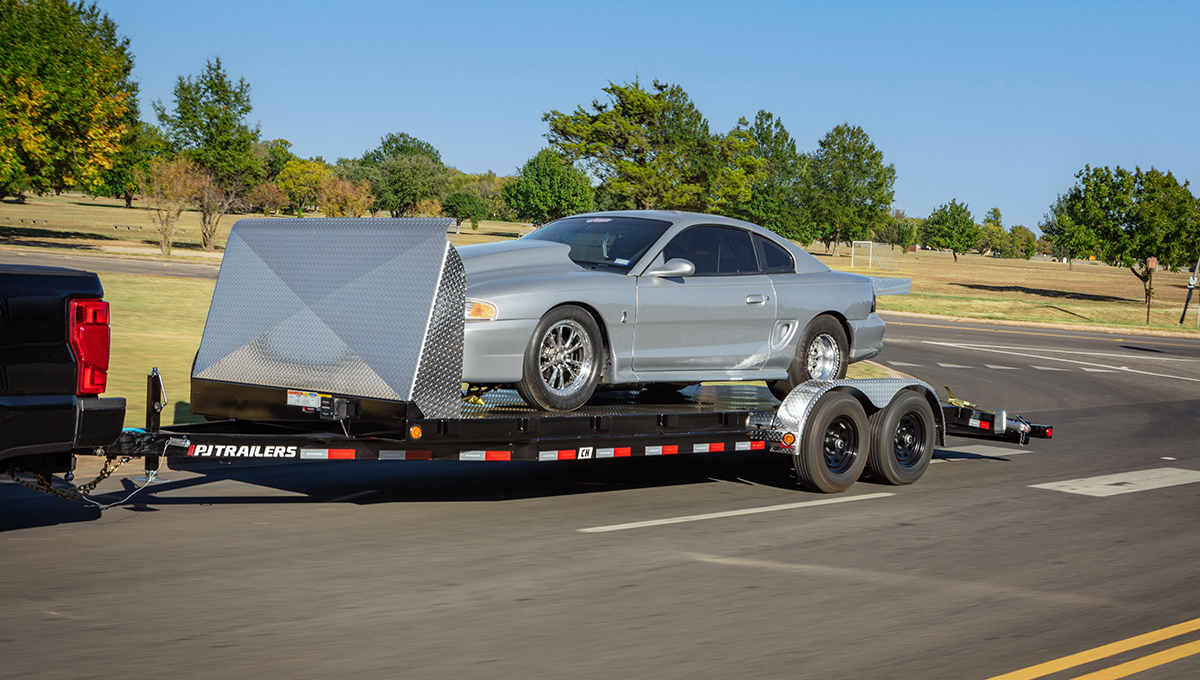 Truck hauling a car on the Steel Deck Car Hauler with rock shield