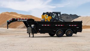 The HD Low-Pro Dump Trailer holding a skid loader