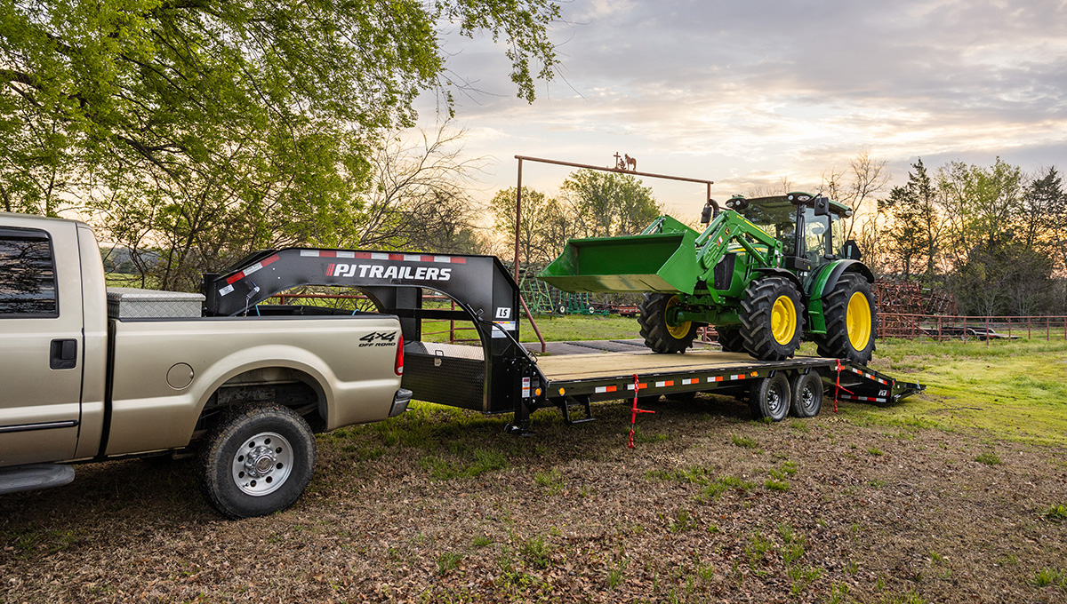 Unloading a John Deere front loader from the Low-Pro Flatdeck Trailer With 7K Singles