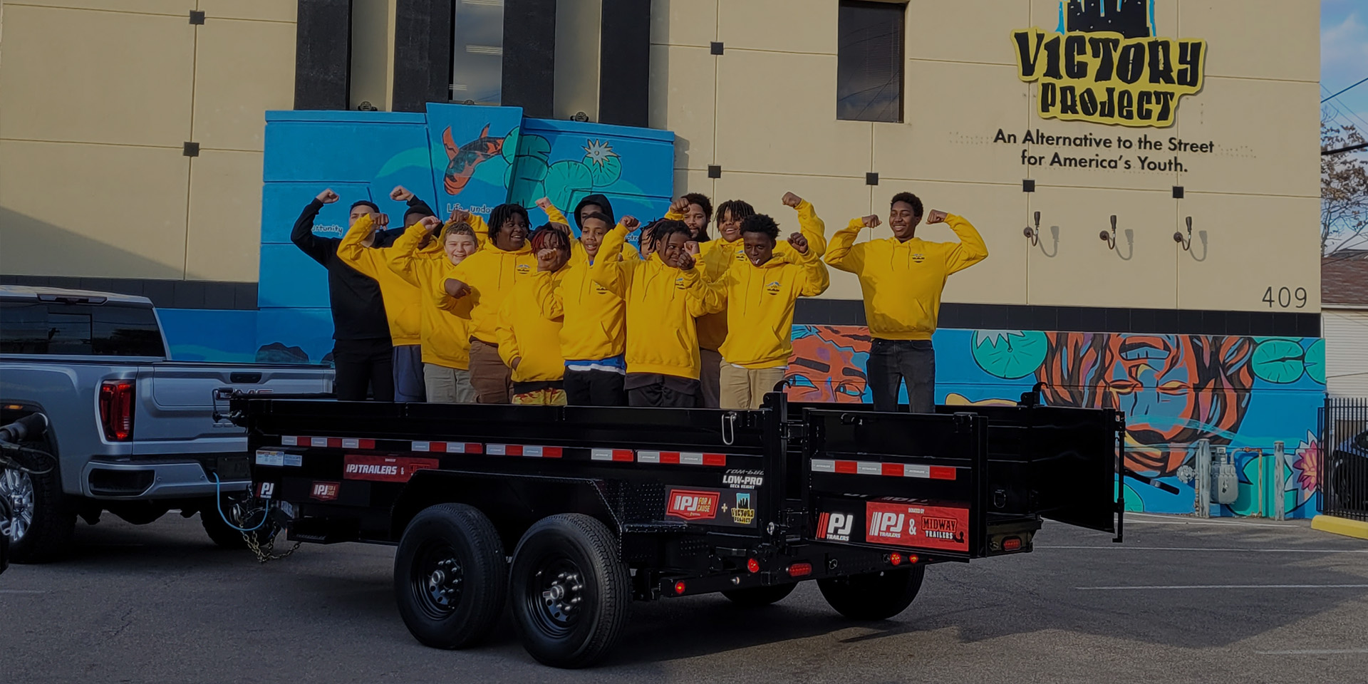pjs for a cause helpers standing on a trailer with yellow sweatshirts on